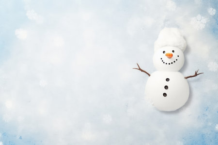 Children's drawing of a finger-drawn snowman on white snow. Top view. Flat lay with text space on thの素材