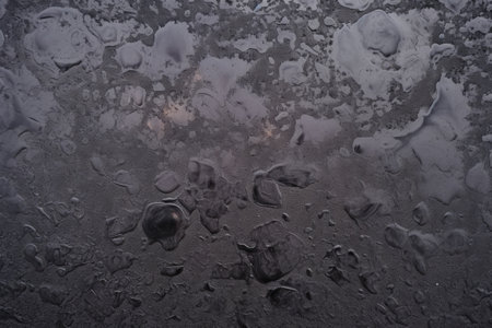 Dirty black engine oil stain on concrete floor background, seen in an old automobile garage.の素材