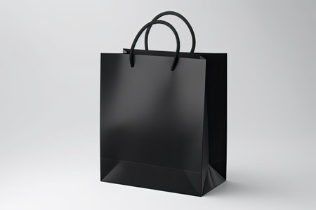 Black handle bag on white surface.の素材