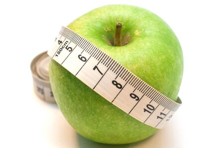 Green apple wrapped by measuring tape isolated on white backgroundの写真素材