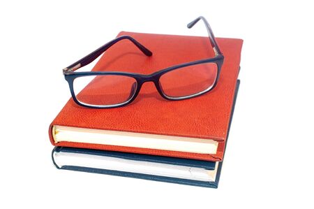 Glasses and stack of books isolated on whiteの写真素材