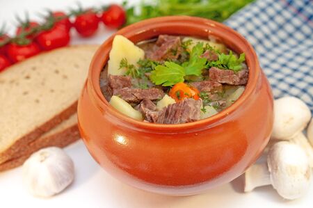 Roast in a pot with beef meat and potatoes on the table.の写真素材