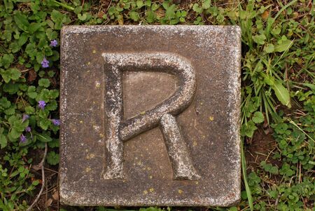 Block with letter R stone, in groundの写真素材