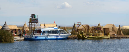 LAKE TITICACA, PERU - AUGUST 6:  Tourist boat and native totora boat on a reed island in Lake Titicaca August 6, 2013. Lake Titicaca is the highest navigable lake in the world. のeditorial素材