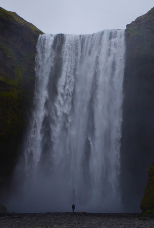 NEAR SKOGAR, ICELAND - JUN 15:  A person stands before Skogafoss waterfall on June 15, 2015. The fall was in the film The Secret Life of Walter Mitty in 2013.のeditorial素材