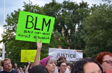 ANN ARBOR, MI - AUG 13: A woman holds up a sign at a rally in solidarity with the counter-protesters of Charlottesville in Ann Arbor, MI on August 13, 2017.のeditorial素材