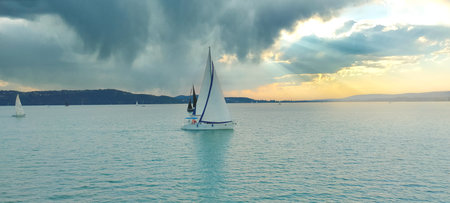Sailboat in the sea in the evening with cinematic sunsetの写真素材