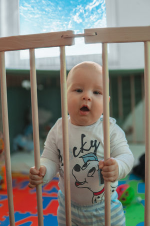 baby boys trying to stand up in his crib