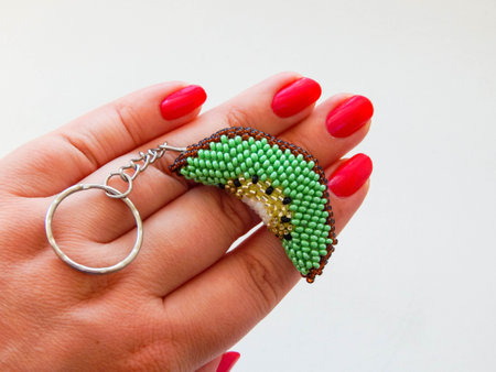 Fruit keychain lies on a woman's palm