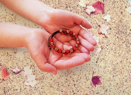 Female hands with colorful bracelet. Female hands with orange braceletの写真素材