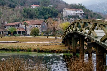 House in the mountains, snow and wooden bridge. A rustic mountain home. A bridge with wooden planks,...