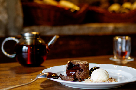 chocolate Fondan with syrup and ice-cream on a plate and turkish tea in traditional glassの写真素材