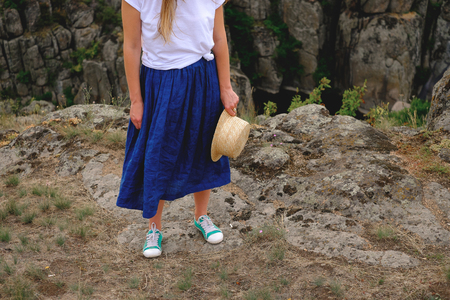 Photo of female legs in gumshoes on the background of the canyonの写真素材
