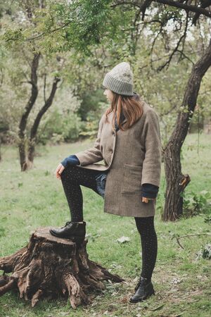 Outdoors lifestyle fashion portrait of pretty young woman walking on the autumn park.の写真素材