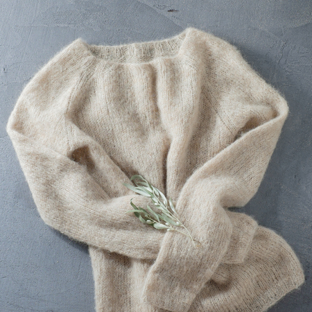 Pastel beige knitted woolen sweater on a hangerの写真素材