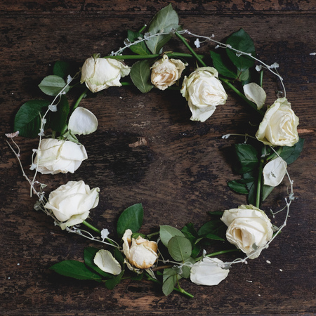 Wreath of white roses on a wooden background.の写真素材