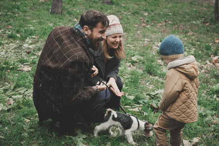 Parents give the child a dog fox terrier. Outdoorの写真素材