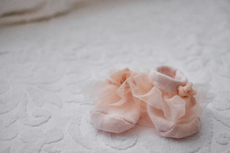 Pink baby booties on white background with copy spaceの写真素材