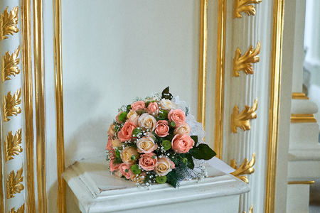 Beautiful wedding bouquet in rustic style with roses on gold backgroundの写真素材