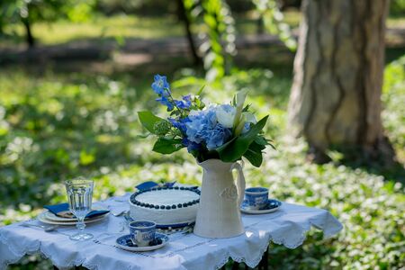 Cake with blue cream for men, decorated with blackberry and blueberry. Hands of Chef decorate the cake with berries. Selective focus.の写真素材