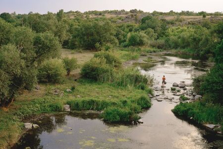 landscape with mountains, forest and a river in front. beautiful sceneryの写真素材