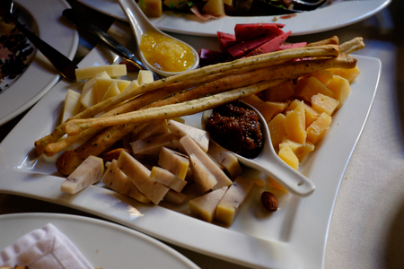 Cheese plate on a white table. Many kinds of cheese on a plateの写真素材