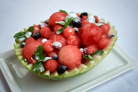 Basket of ripe juicy watermelon balls and sugar powderの写真素材