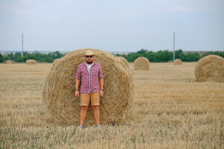 man resting after hay harvesting in haystacksの写真素材