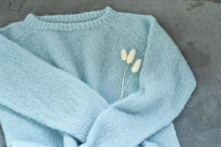 Blue knitted sweater handmade isolated gray backroundの写真素材