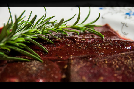pork liver sprinkled with spices, twig of fresh thyme, ready for grilling, close-up viewの写真素材