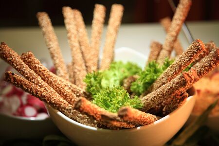 bread sticks with sesame on a white bowl as a starter