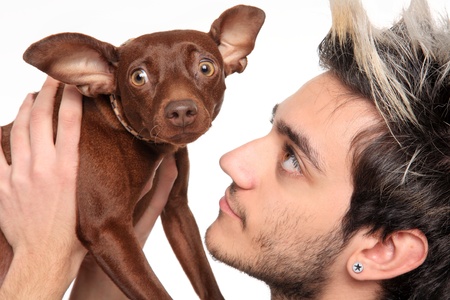 young man posing with pinscher isolated on a white backgroundの写真素材