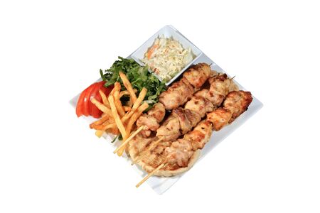 chicken skewers served on a plate with fried potatoes tzatziki and pita isolated on a white backgroundの写真素材