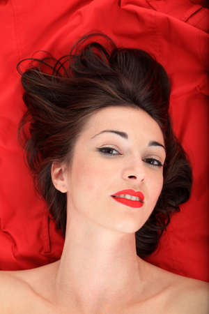 portrait of a beautiful girl lay down on a red jacket