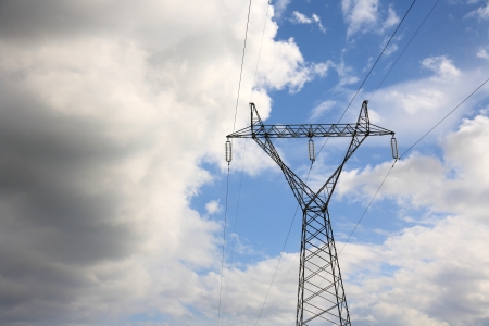 high voltage electric pylon against cloudy blue skyの写真素材