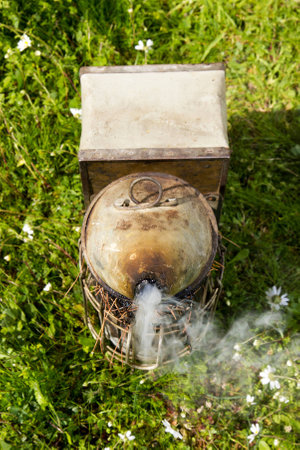 bee smoker with smoke on the ground at farmの写真素材