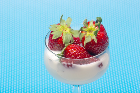 fresh strawberries on a glass filled with cream の写真素材
