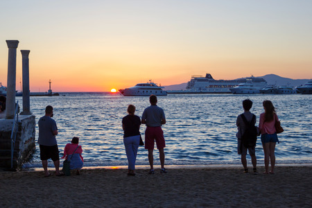 tourists watching the sunset in mykonos port,Greeceのeditorial素材