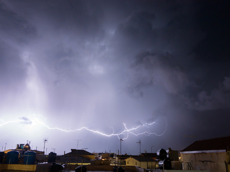 big strike in the sky with storm above a city