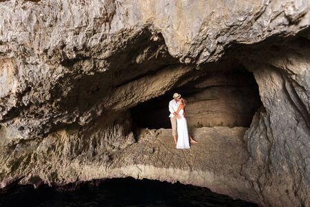 portrait of a young couple in love, inside a cave of  a greek islandの写真素材