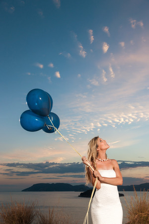 portrait of a beautiful bride with balloons enjoy the sunset in the natureの写真素材