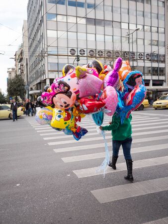 ATHENS,GREECE - MARCH 26,2016: Young girl holding balloons for sale in the streets of Athens,Greeceのeditorial素材