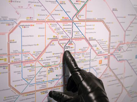 BERLIN, GERMANY - JANUARY 3, 2016: Girl's hand with a leather glove pointing in the map of the train...