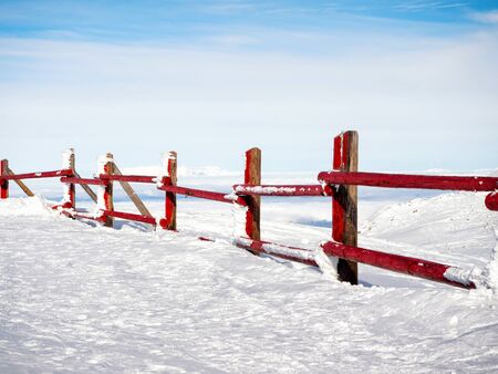 Red frozen fence at  the top of the mountain Helmos in Kalavrita ski resort in a sunny dayの写真素材