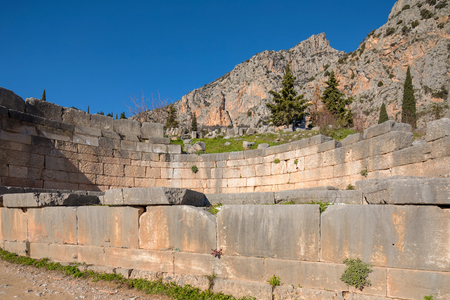 Ruins of Delphi archaeological site with snow in a winter day with sun