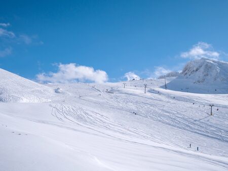 Parnassos mountain with snow and people on the slopes in a sunny dayの写真素材