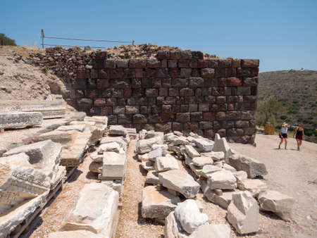MILOS - GREECE, JULY 14, 2017: Tourists visit an ancient Roman theatre in Milos island, Greeceのeditorial素材