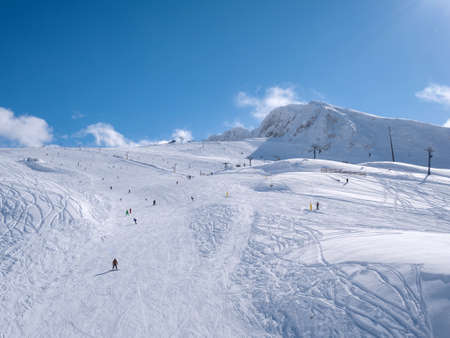 Parnassos mountain with snow and people on the slopes in a sunny dayの写真素材