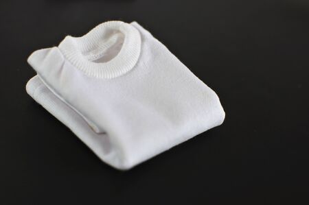 White t-shirts folded on a black backgroundの写真素材