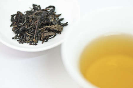 Cup of chinese tea with dry tea leaves isolated on white backgroundの写真素材